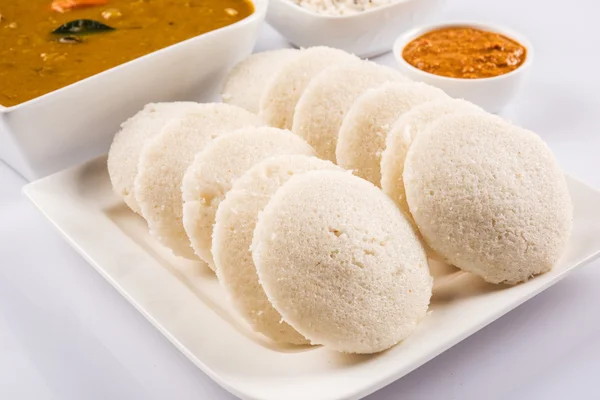 Comida tradicional indiana sul, idli ou idly com sambar e chutney de coco branco e chutney vermelho em placa quadrada de cerâmica branca e tigela em fundo branco, vista frontal isolada em fundo branco — Fotografia de Stock