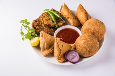 kişniş vada veya kothimbir vada, samosa, kachori, kahverengi ahşap plakalar üzerinde daal vada. Hint çeşitli aperatifler. Hint atıştırmalıkları kombinasyonu. Hint aperatifler grubu, Hint favori aperatifler, Asya baharatlı aperatifler