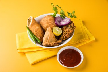 kişniş vada veya kothimbir vada, samosa, kachori, kahverengi ahşap plakalar üzerinde daal vada. Hint çeşitli aperatifler. Hint atıştırmalıkları kombinasyonu. Hint aperatifler grubu, Hint favori aperatifler, Asya baharatlı aperatifler