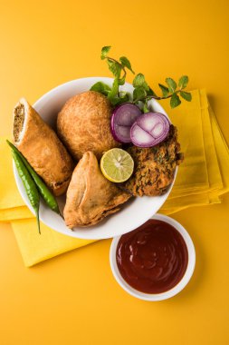 kişniş vada veya kothimbir vada, samosa, kachori, kahverengi ahşap plakalar üzerinde daal vada. Hint çeşitli aperatifler. Hint atıştırmalıkları kombinasyonu. Hint aperatifler grubu, Hint favori aperatifler, Asya baharatlı aperatifler