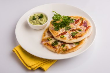 güney hint gıda, kişniş yaprağı ile beyaz seramik plaka hindistan cevizi chutney ile iki uttapam, closeup ve ön görünümü, izole