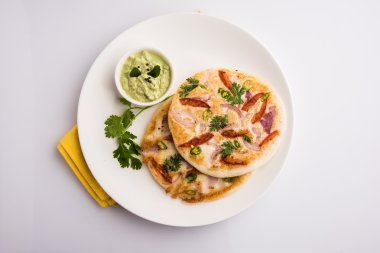 güney hint gıda, kişniş yaprağı ile beyaz seramik plaka hindistan cevizi chutney ile iki uttapam, closeup ve ön görünümü, izole