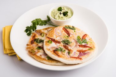 güney hint gıda, kişniş yaprağı ile beyaz seramik plaka hindistan cevizi chutney ile iki uttapam, closeup ve ön görünümü, izole
