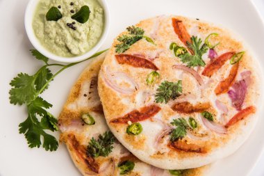 güney hint gıda, kişniş yaprağı ile beyaz seramik plaka hindistan cevizi chutney ile iki uttapam, closeup ve ön görünümü, izole