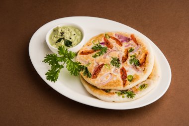 güney hint gıda, kişniş yaprağı ile beyaz seramik plaka hindistan cevizi chutney ile iki uttapam, closeup ve ön görünümü, izole