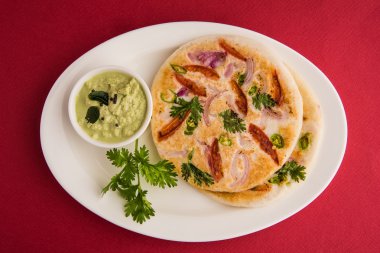 güney hint gıda, kişniş yaprağı ile beyaz seramik plaka hindistan cevizi chutney ile iki uttapam, closeup ve ön görünümü, beyaz arka plan üzerinde izole