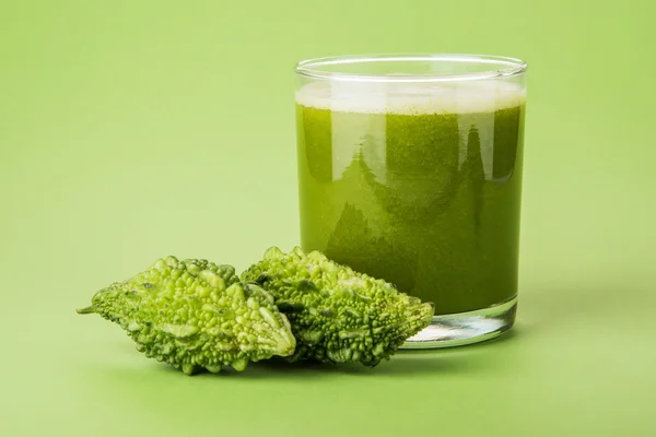 Jus de momodica vert à base de plantes dans un verre avec des légumes tranchés, du jus de karela ou du jus de gourdes amères — Photo