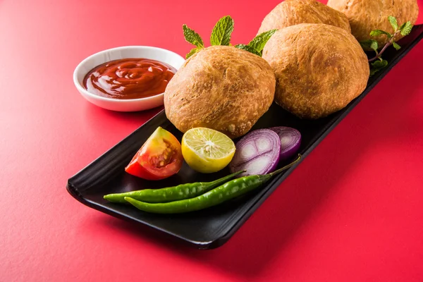 Kachori or Kachauri or Kachodi or Katchuri is a spicy snack popular in various parts India, pakistan. with green salad, pudina chutney and tea in white crockery