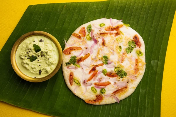 Comida indiana sul, dois uttapam com chutney de coco em placa cerâmica branca com folha de coentro, closeup e vista frontal, isolados — Fotografia de Stock