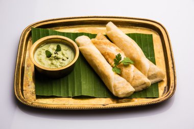 Hindistan cevizi yaprağı üzerinde pirinç tepsihindistan cevizi chutney ile 3 dosa rulo, favori güney hint yemek, üst görünümü, beyaz arka plan üzerinde izole