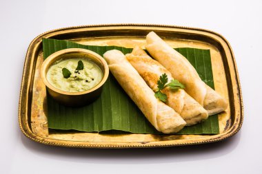 Hindistan cevizi yaprağı üzerinde pirinç tepsihindistan cevizi chutney ile 3 dosa rulo, favori güney hint yemek, üst görünümü, beyaz arka plan üzerinde izole