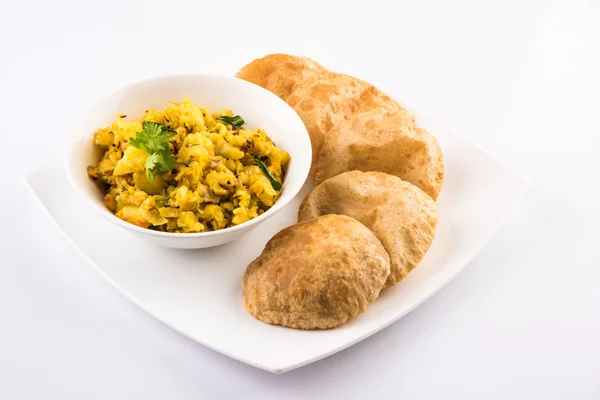 Індійський напівсухий картопляний гострий рецепт, також відомий як аалу бджі або алу сабджі, який подають з індійським пурі або порі — стокове фото