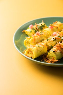 khandvi gram un ve susam ile temperli curds ile yapılan Hindistan'dan bir gujarati çerezim ve hardal olarak da bilinen Surali chya Vadya/dolma Khandvi, seçici odak tohum