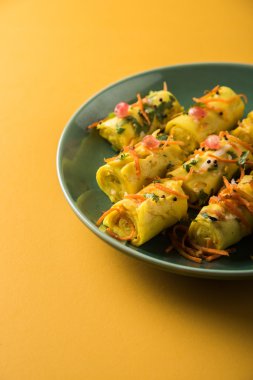 khandvi gram un ve susam ile temperli curds ile yapılan Hindistan'dan bir gujarati çerezim ve hardal olarak da bilinen Surali chya Vadya/dolma Khandvi, seçici odak tohum