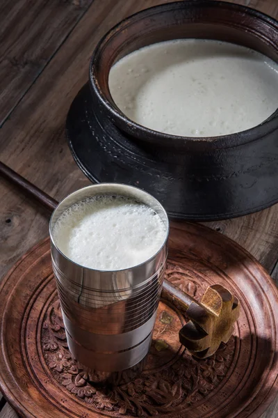Süße indische Lassi aus Milch, Quark, Zucker und Salz, vermischt mit Eiswürfeln, serviert in einem Jumbo-Stahlglas, zubereitet in einem traditionellen Tontopf — Stockfoto