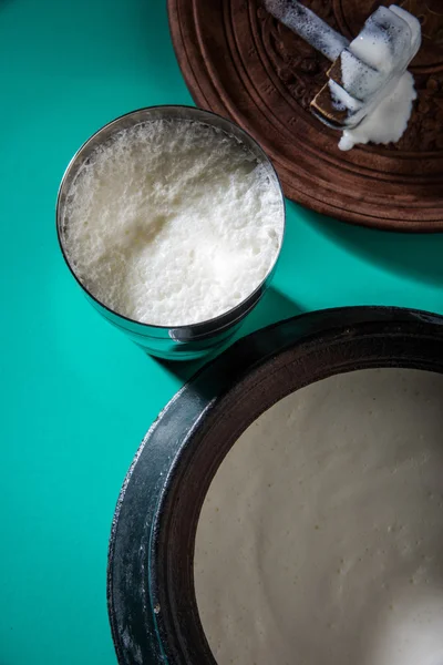 印度甜酸奶组成的牛奶、 豆腐、 糖和盐混合在冰块，在巨型钢玻璃，准备在传统砂锅 — 图库照片
