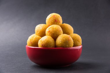 pile of indian sweet bundi laddu or motichur laddu stacked in a red bowl, selective focus clipart