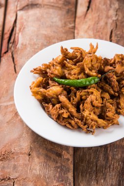 Soğan Bhajis kızarmış yeşil biber ve domates ketçap ile görev yaptı.