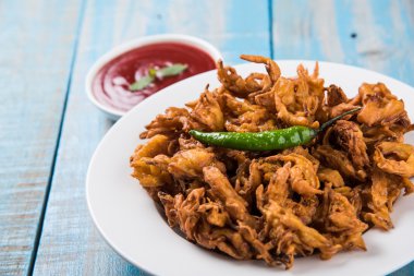 Çıtır soğan bhaji veya kanda bhaji veya kızarmış soğan pakore veya pakode, lezzetli sokak gıda, favori Hint aperatif muson içinde sıcak çay ile servis