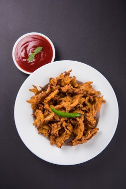 Çıtır soğan bhaji veya kanda bhaji veya kızarmış soğan pakore veya pakode, lezzetli sokak gıda, favori Hint aperatif muson içinde sıcak çay ile servis