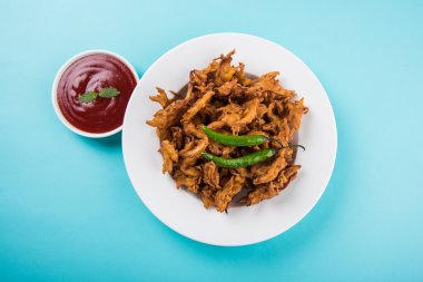 Çıtır soğan bhaji veya kanda bhaji veya kızarmış soğan pakore veya pakode, lezzetli sokak gıda, favori Hint aperatif muson içinde sıcak çay ile servis