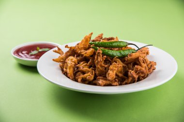 Çıtır soğan bhaji veya kanda bhaji veya kızarmış soğan pakore veya pakode, lezzetli sokak gıda, favori Hint aperatif muson içinde sıcak çay ile servis