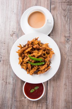 Çıtır soğan bhaji veya kanda bhaji veya kızarmış soğan pakore veya pakode, lezzetli sokak gıda, favori Hint aperatif muson içinde sıcak çay ile servis