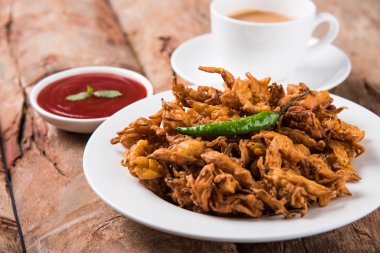 Çıtır soğan bhaji veya kanda bhaji veya kızarmış soğan pakore veya pakode, lezzetli sokak gıda, favori Hint aperatif muson içinde sıcak çay ile servis