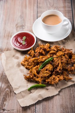 Çıtır soğan bhaji veya kanda bhaji veya kızarmış soğan pakore veya pakode, lezzetli sokak gıda, favori Hint aperatif muson içinde sıcak çay ile servis