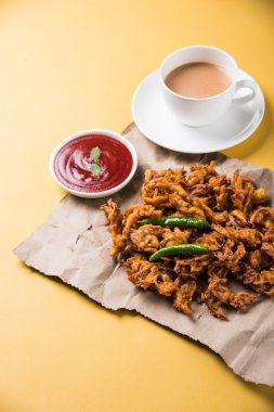 Çıtır soğan bhaji veya kanda bhaji veya kızarmış soğan pakore veya pakode, lezzetli sokak gıda, favori Hint aperatif muson içinde sıcak çay ile servis