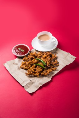 Çıtır soğan bhaji veya kanda bhaji veya kızarmış soğan pakore veya pakode, lezzetli sokak gıda, favori Hint aperatif muson içinde sıcak çay ile servis