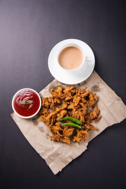 Çıtır soğan bhaji veya kanda bhaji veya kızarmış soğan pakore veya pakode, lezzetli sokak gıda, favori Hint aperatif muson içinde sıcak çay ile servis
