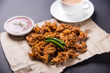 Çıtır soğan bhaji veya kanda bhaji veya kızarmış soğan pakore veya pakode, lezzetli sokak gıda, favori Hint aperatif muson içinde sıcak çay ile servis