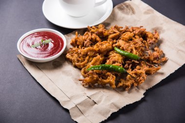 Çıtır soğan bhaji veya kanda bhaji veya kızarmış soğan pakore veya pakode, lezzetli sokak gıda, favori Hint aperatif muson içinde sıcak çay ile servis