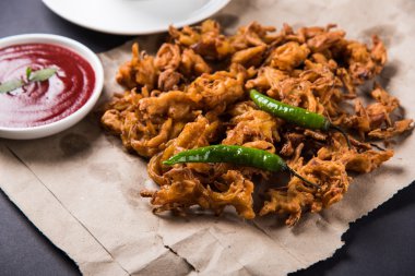 Çıtır soğan bhaji veya kanda bhaji veya kızarmış soğan pakore veya pakode, lezzetli sokak gıda, favori Hint aperatif muson içinde sıcak çay ile servis