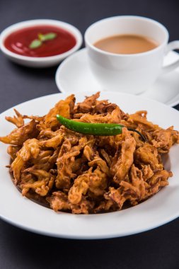 Çıtır soğan bhaji veya kanda bhaji veya kızarmış soğan pakore veya pakode, lezzetli sokak gıda, favori Hint aperatif muson içinde sıcak çay ile servis