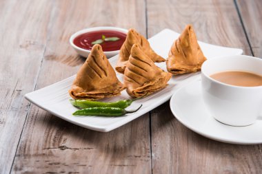 Çıtır soğan bhaji veya kanda bhaji veya kızarmış soğan pakore veya pakode, lezzetli sokak gıda, favori Hint aperatif muson içinde sıcak çay ile servis