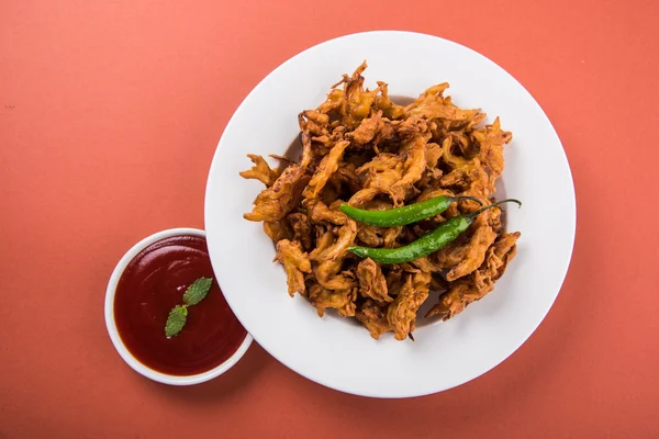 Ropogós hagyma bhaji vagy bhaji Péter vagy sült hagyma pakore vagy pakode, ízletes utcai étel, kedvenc indiai ételt monszun tálalva forró tea — Stock Fotó