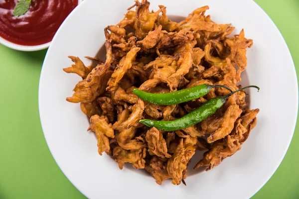 Bhaji cebula chrupiąca lub kanda bhaji lub smażonej cebuli pakore lub pakode, pyszne, Sprzedawcy uliczni, ulubiona indian przekąska w monsoon serwowane z gorącą herbatą — Zdjęcie stockowe