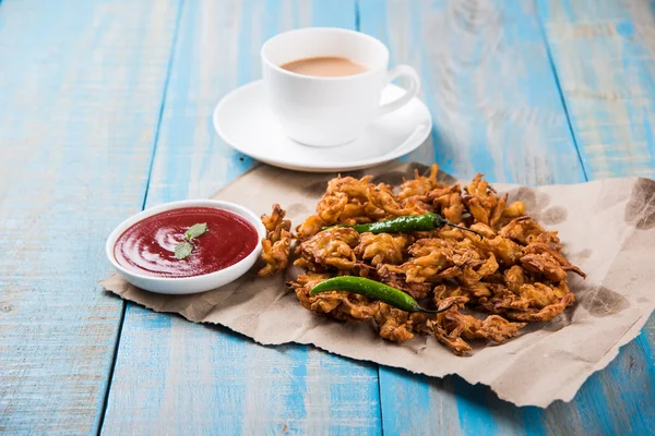 Cebola crocante bhaji ou kanda bhaji ou pakore de cebola frita ou pakode, comida de rua deliciosa, lanche indiano favorito em monção servida com chá quente — Fotografia de Stock