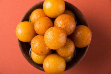 Gulab jamun, ya da gulaab jamun, bir süt-katı tabanlı tatlı mithai ahşap bir kase servis edilir