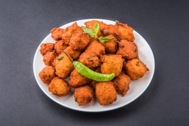 Lezzetli lezzetli ve nefis Hint Moong Dal vada veya moong dal pakoda veya moong vada veya moong vade veya Pakora (börek) ile kızarmış yeşil biber, kırmızı ve yeşil acı sos.