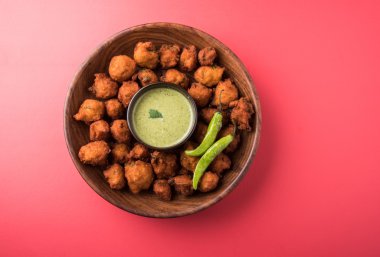 Lezzetli Lezzetli ve Nefis Hint Moong Dal vada veya moong dal pakoda veya moong vada veya moong vade veya Pakora veya pakode (Fritter) kızarmış yeşil biber, kırmızı ve yeşil sıcak sos ile.
