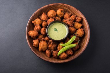 Lezzetli Lezzetli ve Nefis Hint Moong Dal vada veya moong dal pakoda veya moong vada veya moong vade veya Pakora veya pakode (Fritter) kızarmış yeşil biber, kırmızı ve yeşil sıcak sos ile.