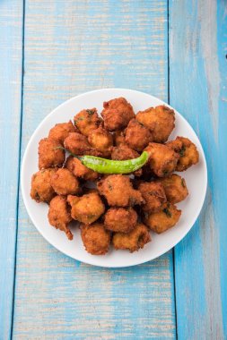 Lezzetli Lezzetli ve Nefis Hint Moong Dal vada veya moong dal pakoda veya moong vada veya moong vade veya Pakora veya pakode (Fritter) kızarmış yeşil biber, kırmızı ve yeşil sıcak sos ile.