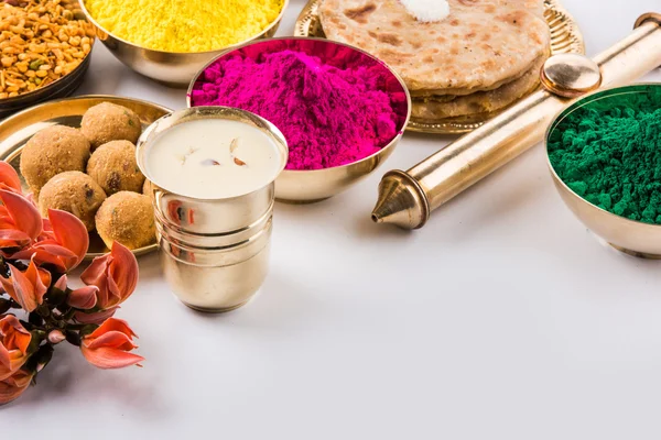 holi festival food with colours, indian festival holi, samosa, kachori, laddu, gujiya, palash flower, thandai, farsan, puran poli or roti, indian festival of colours called holi