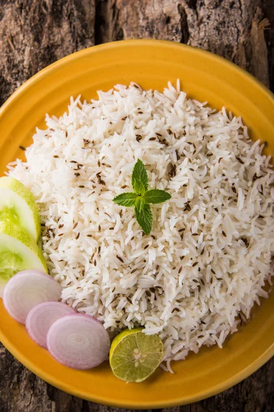 Jeera ris, långkornigt kokt basmati ris smaksatt med stekt kummin, serveras i en gul keramiska plattan med grönsallad — Stockfoto