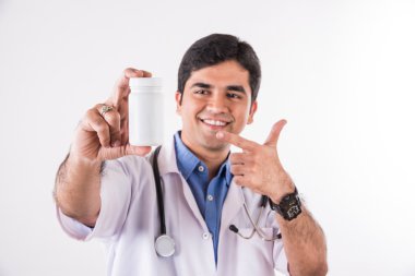 Kendine güvenen Hintli doktor, doktor ya da hemşirenin steteskoplu beyaz ilaç şişesini elinde tutarken çekilmiş portresi.