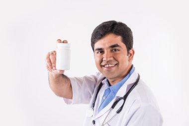 Kendine güvenen Hintli doktor, doktor ya da hemşirenin steteskoplu beyaz ilaç şişesini elinde tutarken çekilmiş portresi.