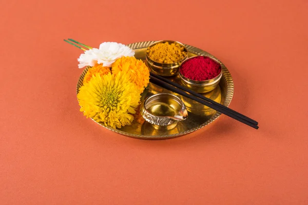 Bellamente decorado Pooja Thali para la celebración diwali para adorar, huldi o cúrcuma en polvo y kumkum, flores, palos perfumados en placa de latón sobre fondo naranja, hindú puja thali —  Fotos de Stock